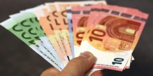 Hand hält verschiedene Euro-Banknoten aufgefächert - Symbolbild für Gehalt