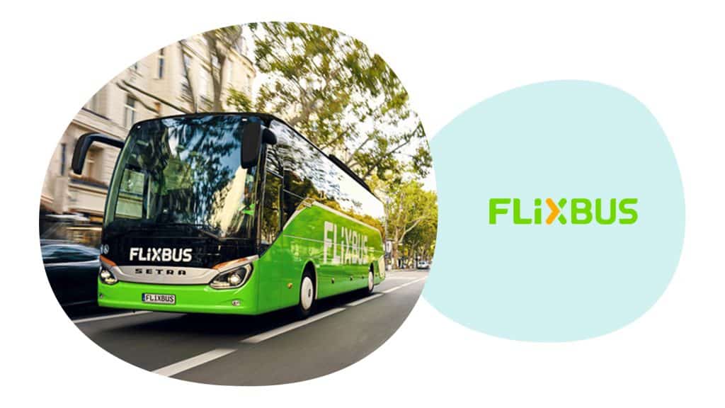 Grüner FlixBus fährt auf der Straße, grüne Bäume im Hintergrund.